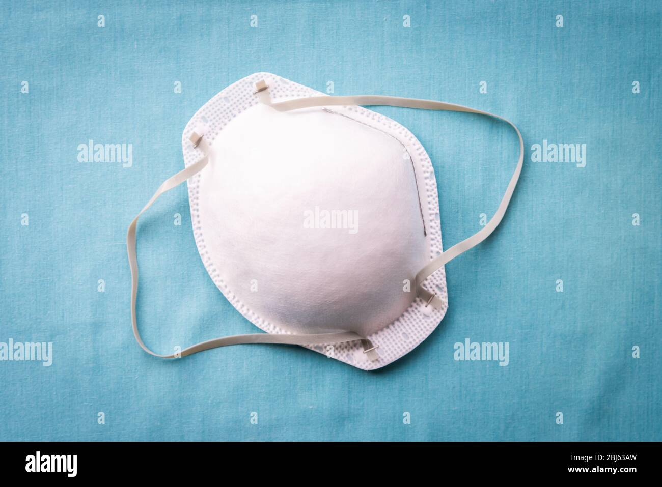 N95 protective face mask on solid blue background Stock Photo