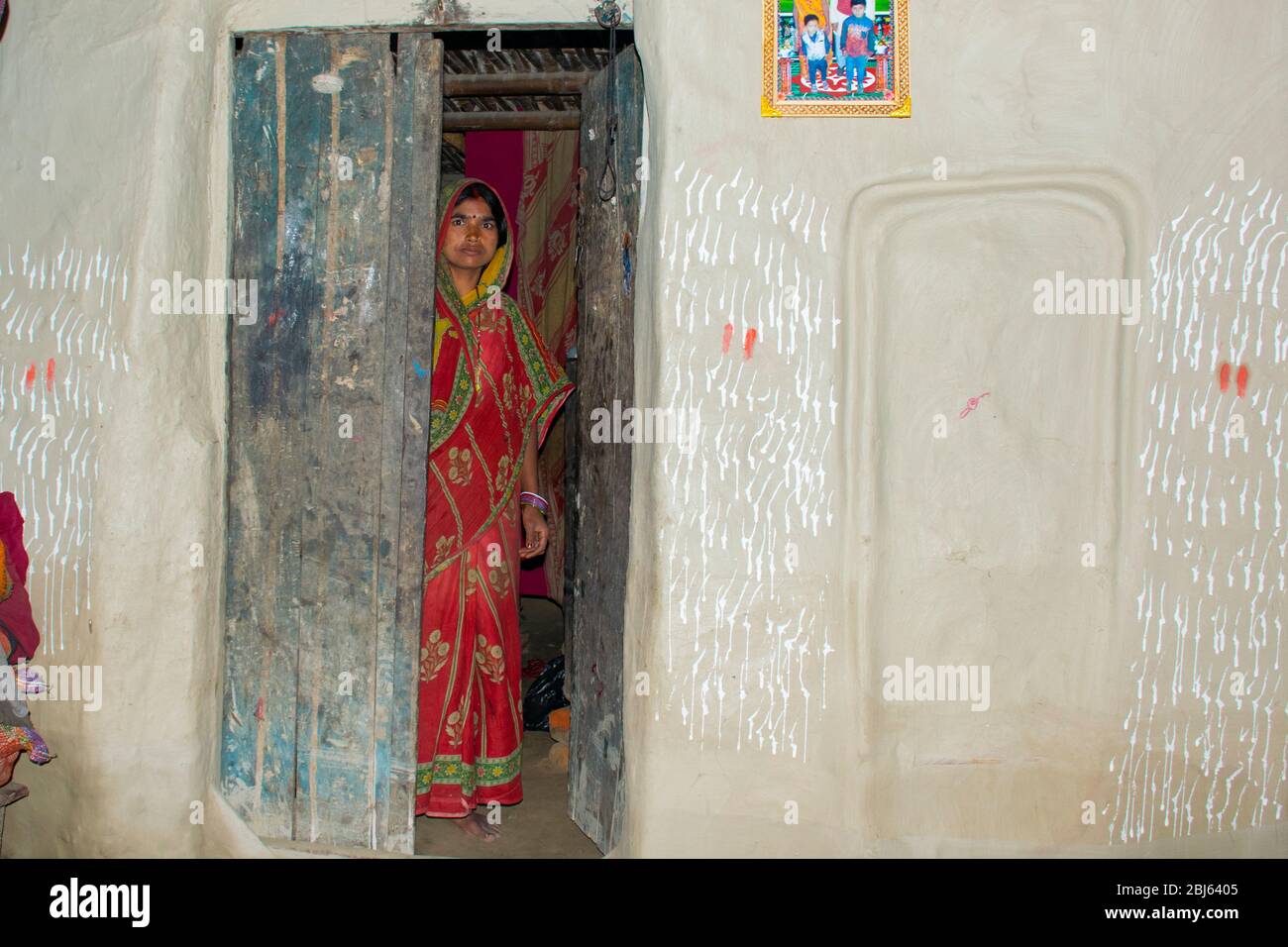 rural woman standing at house door in village, India Stock Photo