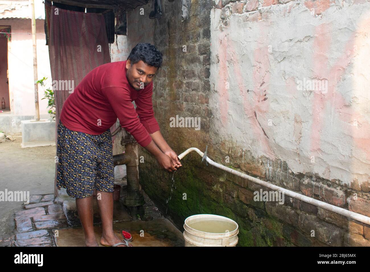 rural man washing hand in drinkable water connection pipe, india Stock Photo