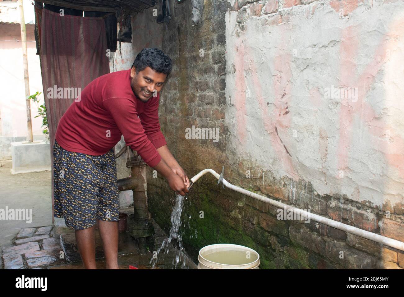 rural man washing hand in drinkable water connection pipe, india Stock Photo