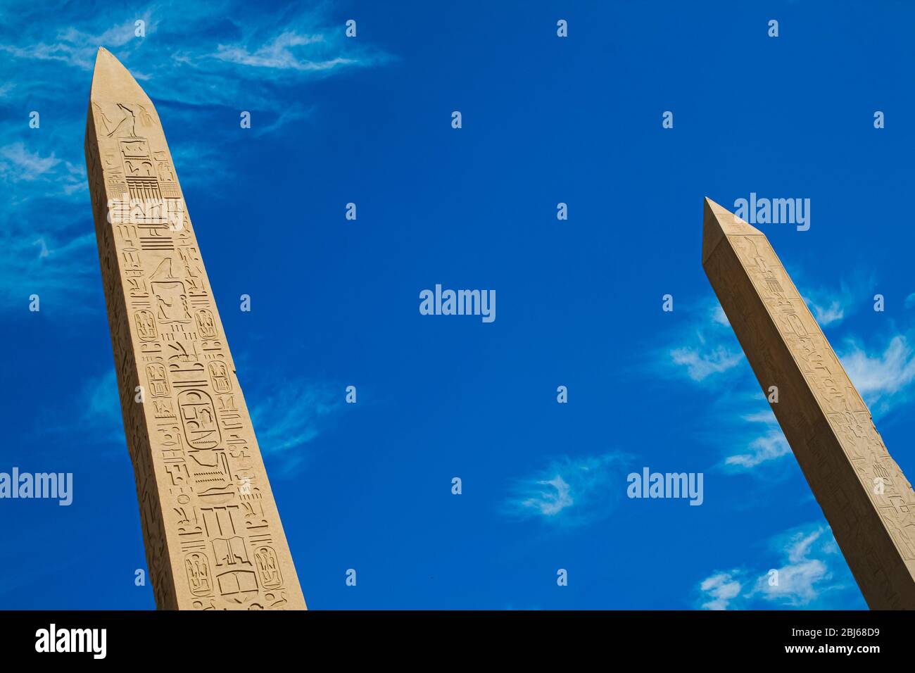 two Obelisks  at the temple of Karnak in Luxor with hieroglyphic carvings on blue sky background Stock Photo