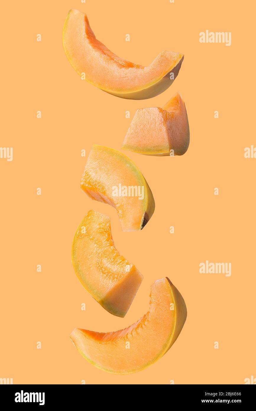 Falling fresh melon isolated on colored background Stock Photo