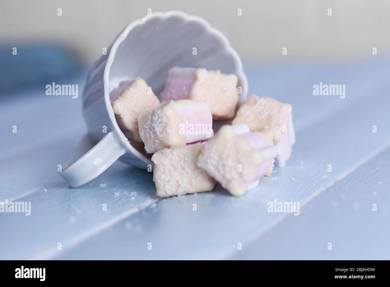 Tasty marshmallows with chocolate in cup on table, close up Stock Photo