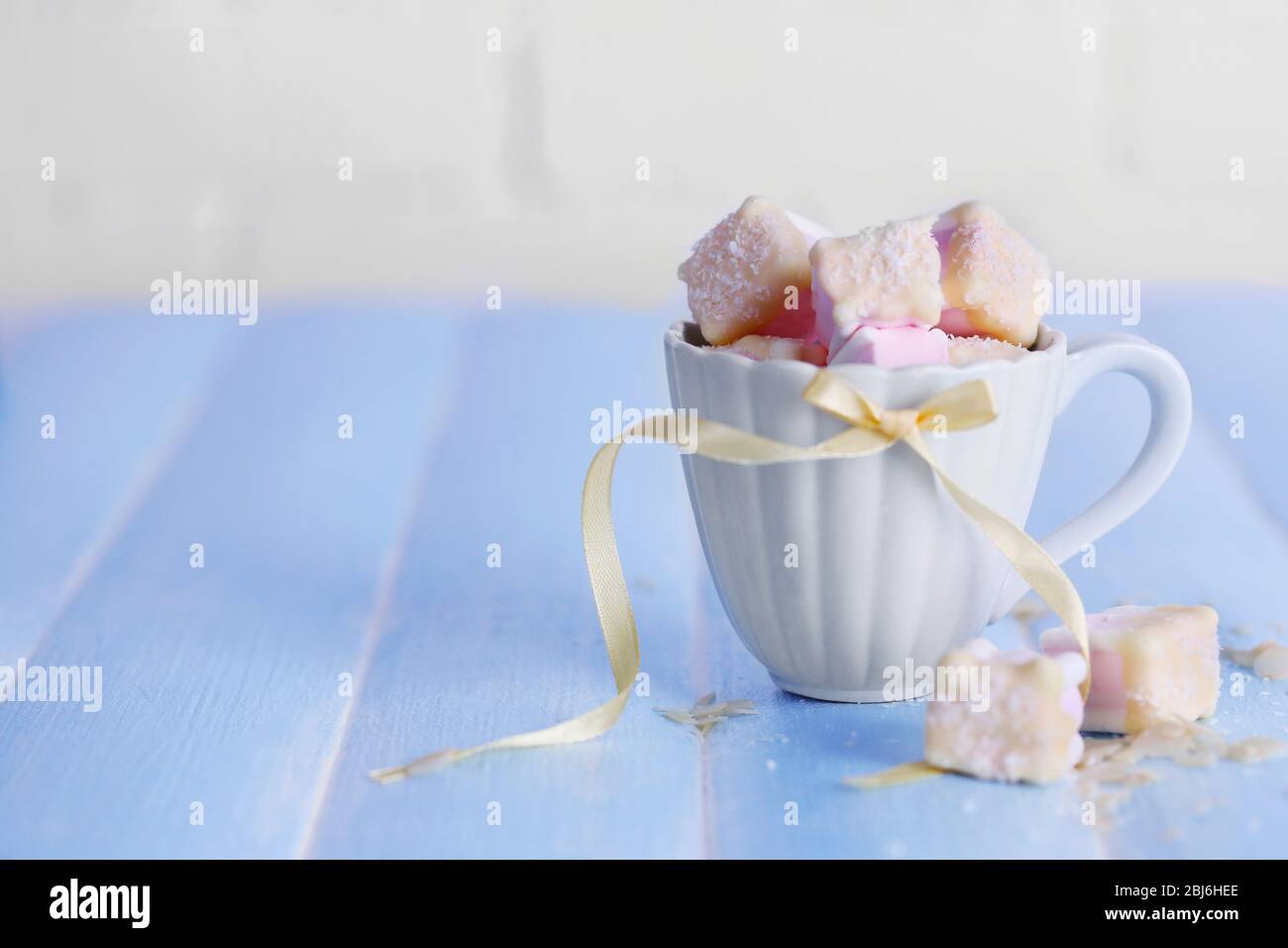 Tasty marshmallows with chocolate in cup on table, close up Stock Photo