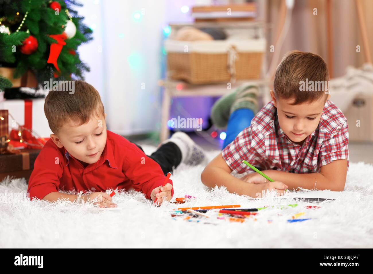 Two cute small brothers drawing on Christmas tree background Stock ...
