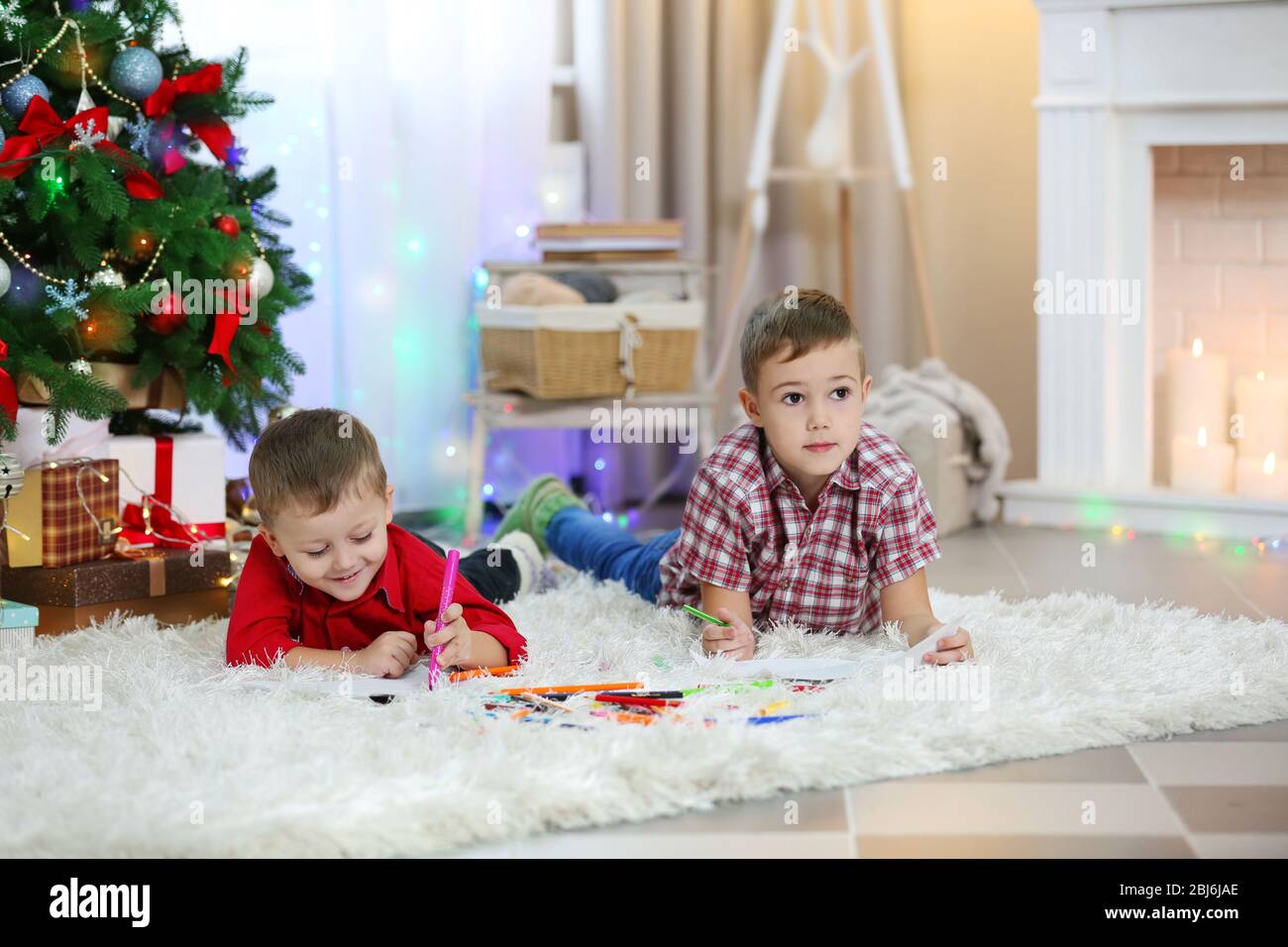 Two cute small brothers drawing on Christmas tree background Stock ...