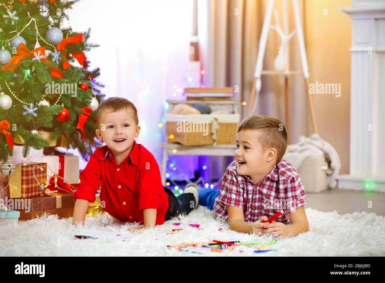 Two cute small brothers drawing on Christmas tree background Stock ...