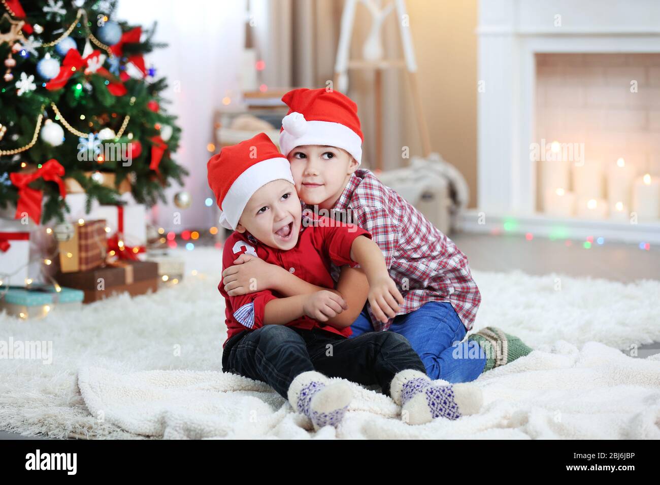 Two cute small brothers hugging on Christmas tree background Stock ...