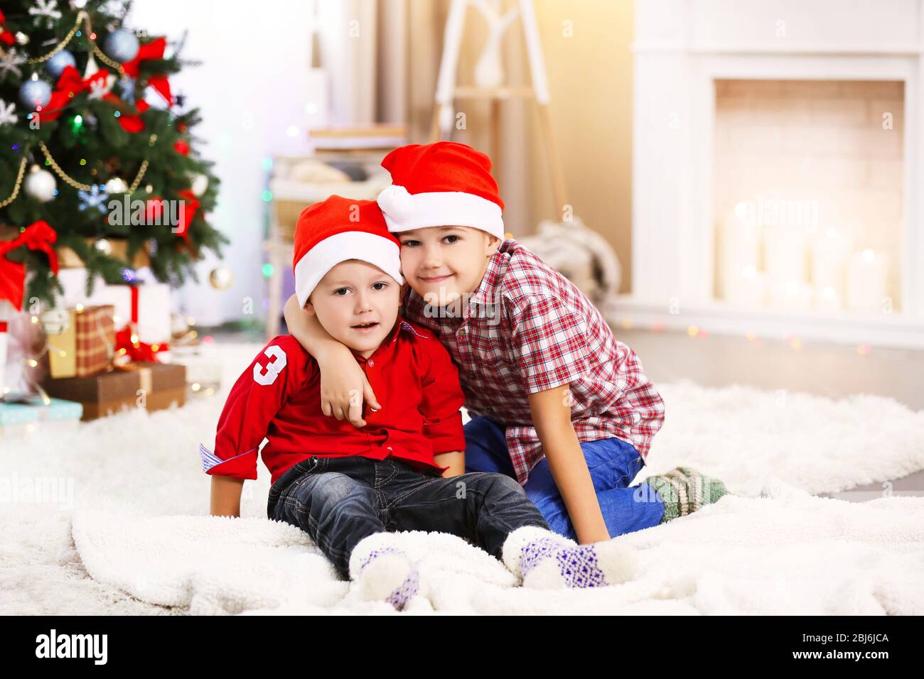 Two cute small brothers hugging on Christmas tree background Stock ...