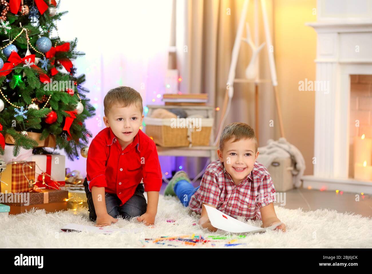 Two cute small brothers drawing on Christmas tree background Stock ...