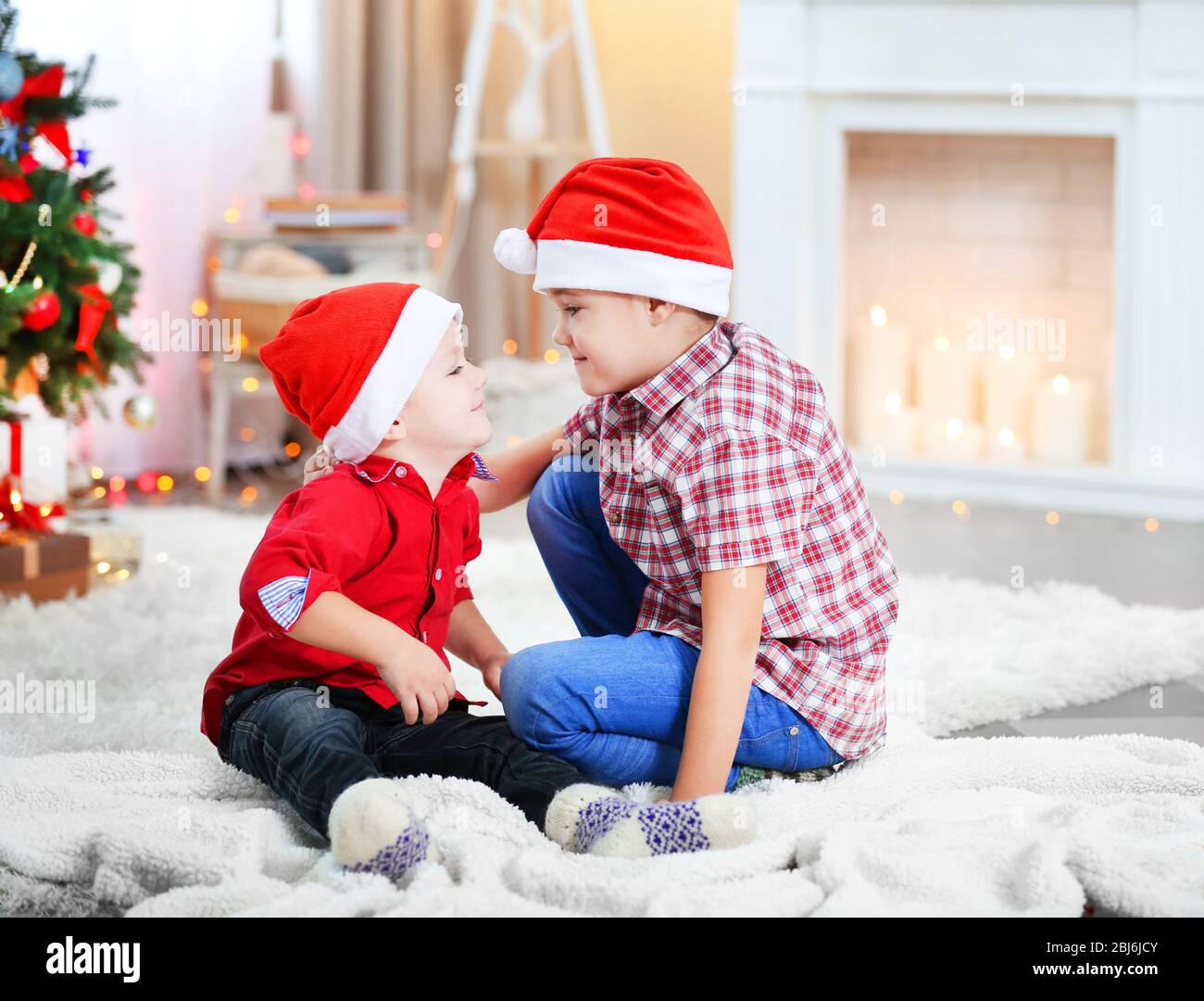 Two cute small brothers playing on fireplace background Stock Photo - Alamy