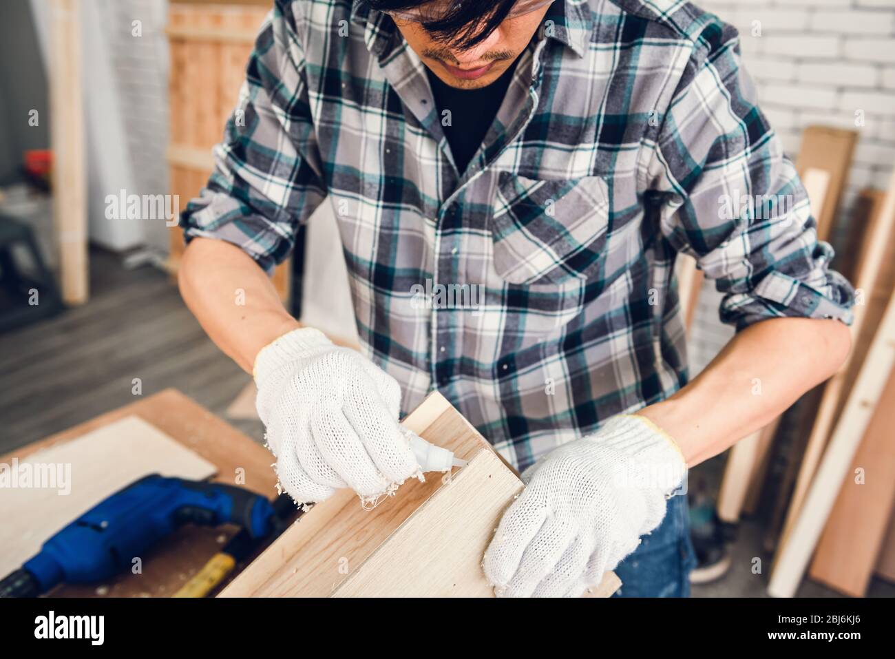 Carpenter Man is Working Timber Woodworking in Carpentry Shop, Craftsman is Screw Coring Timber Frame for Wooden Furniture in Workshop. Workmanship an Stock Photo