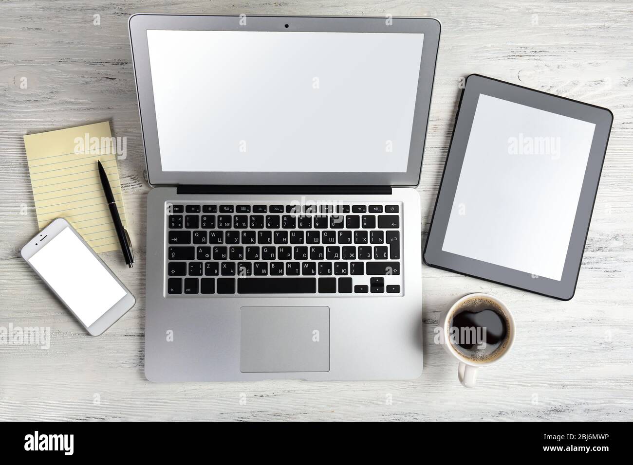 Modern Laptop, Mobile Phone, Tablet, Coffee Cup And Notebook On White 