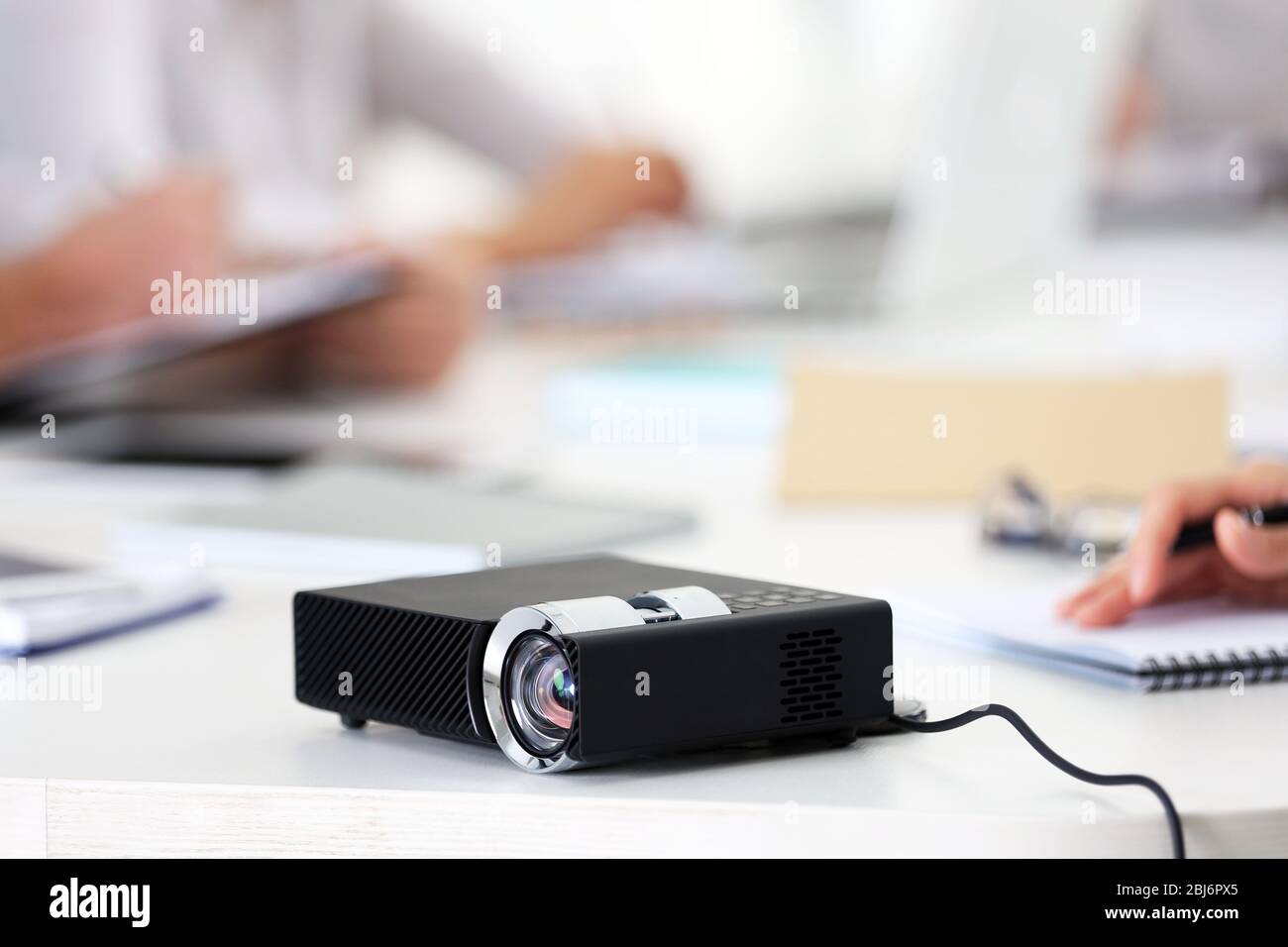 Black projector on white table for business presentation in the ...