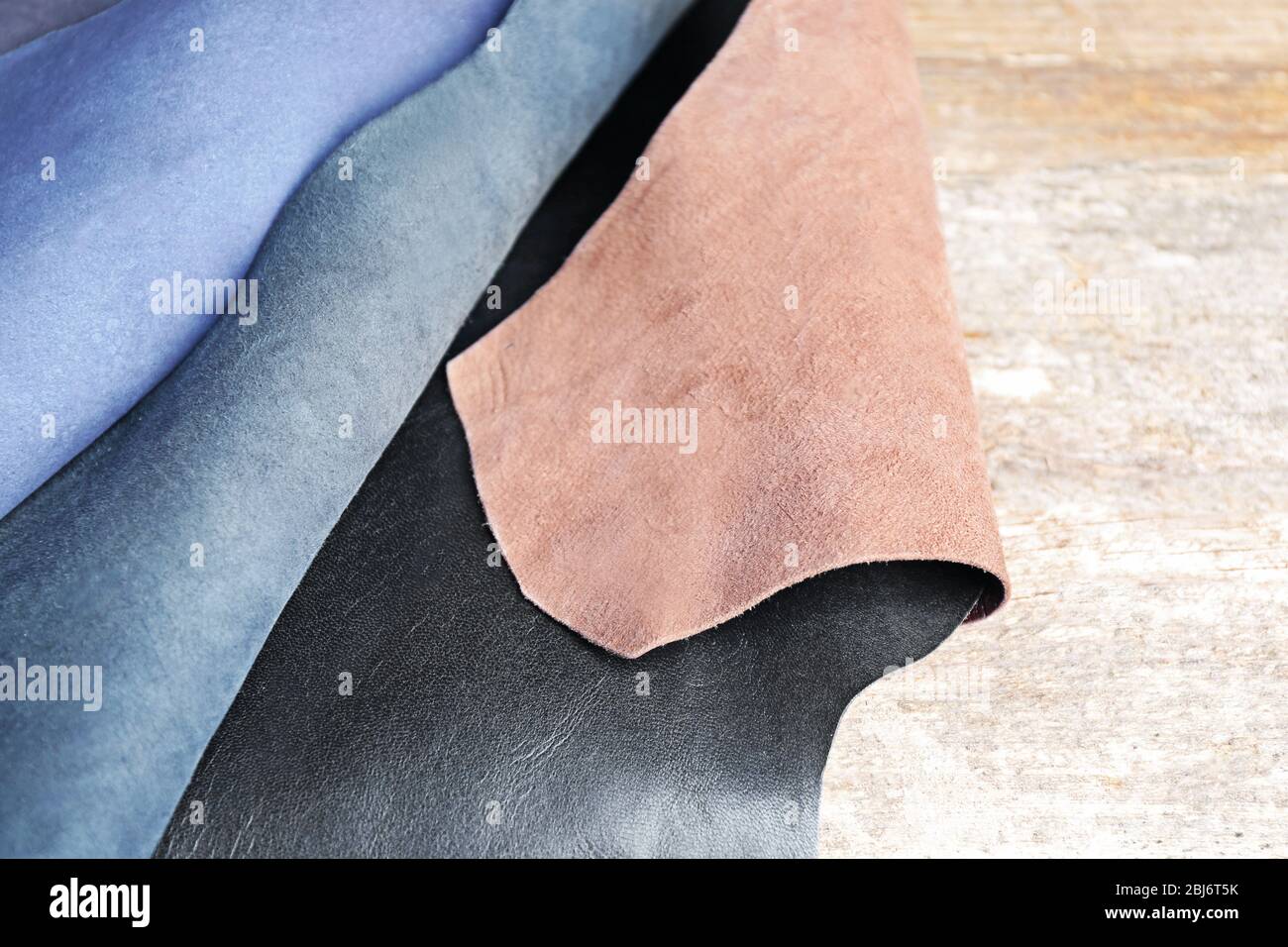Ragged leather material wrong side, on the wooden table, close-up Stock Photo