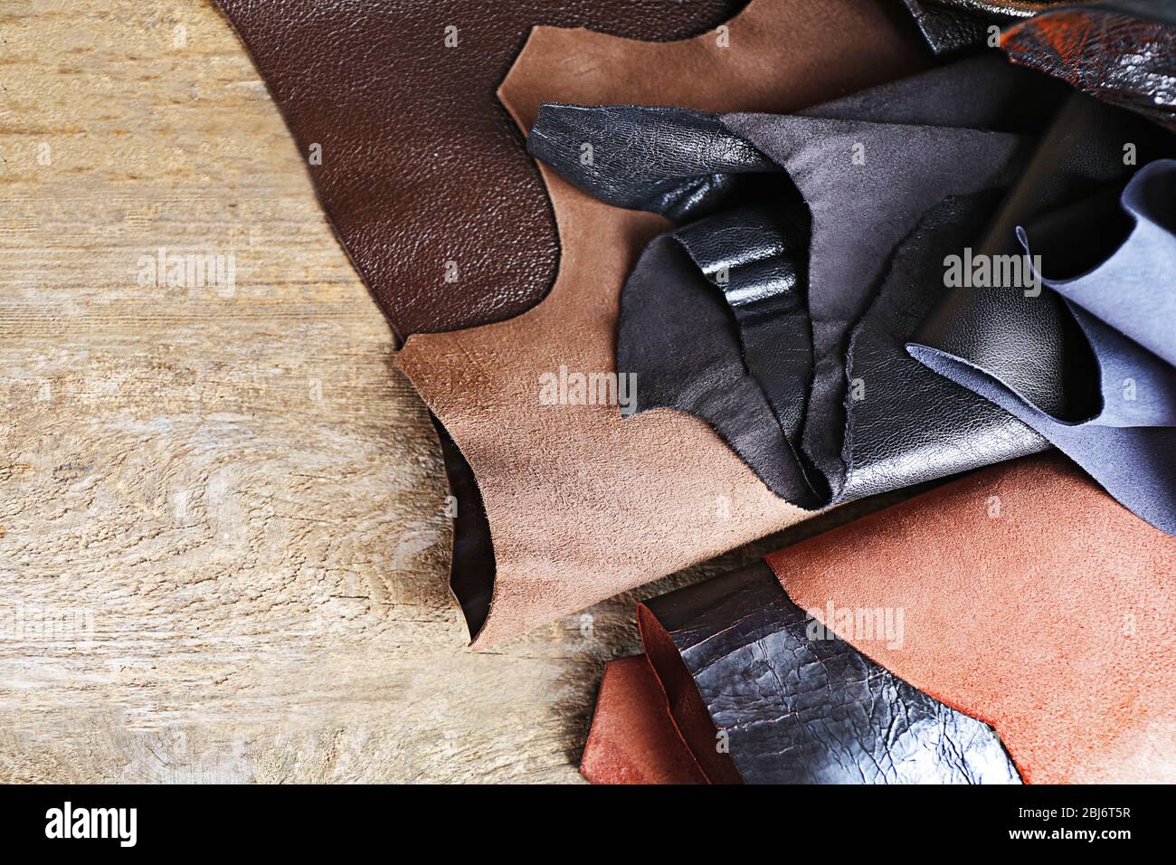 Ragged leather material wrong side, on the wooden table, close-up Stock Photo