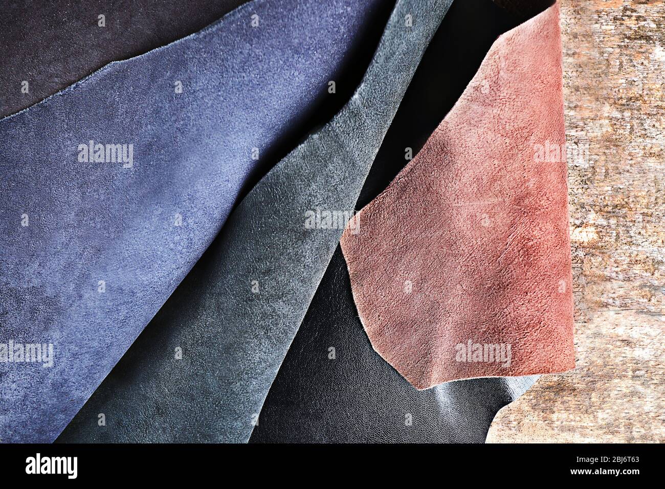 Ragged leather material wrong side, on the wooden table, close-up Stock Photo