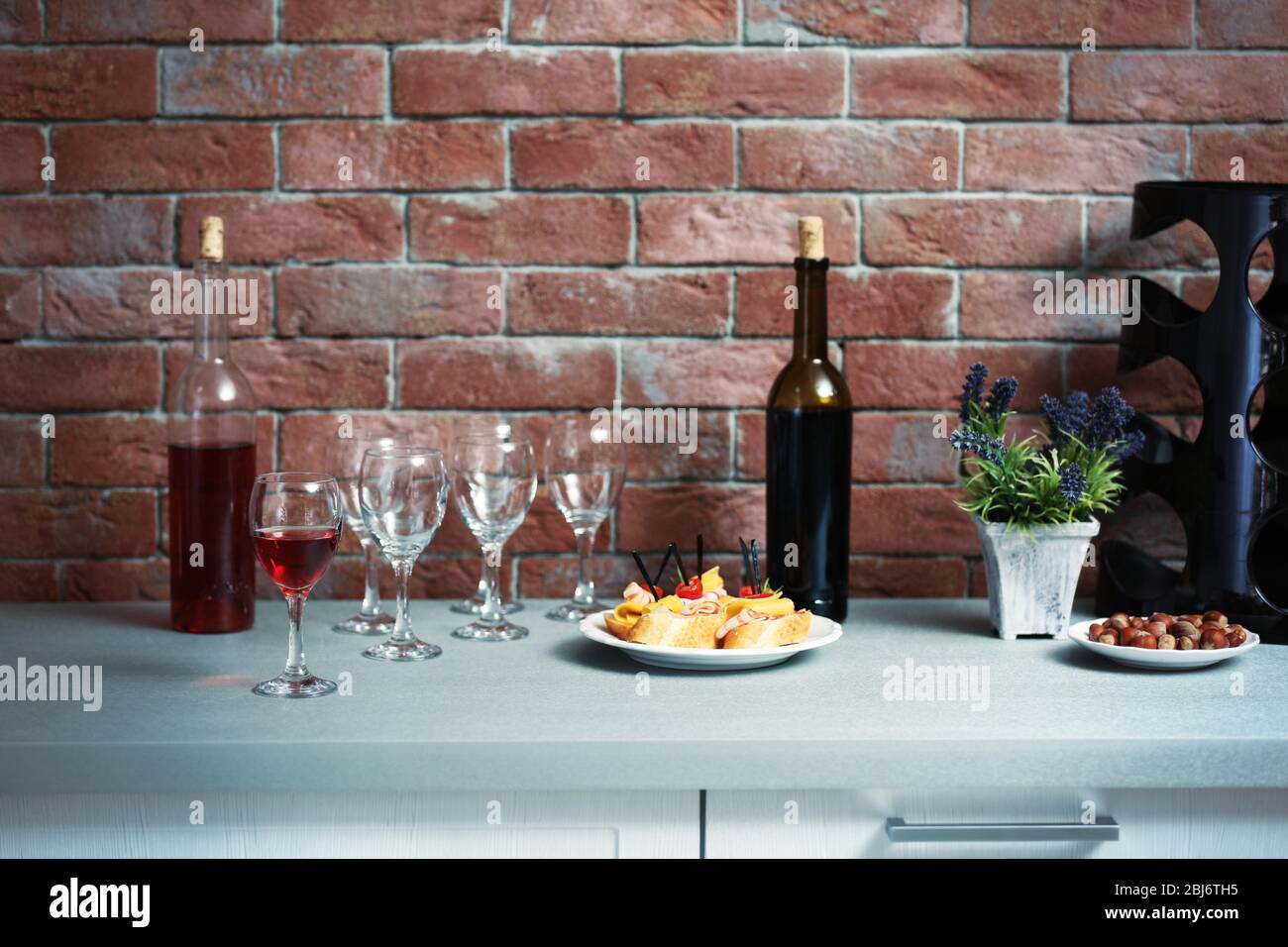 Wine bottles and canape on the kitchen table against a brick wall Stock  Photo - Alamy