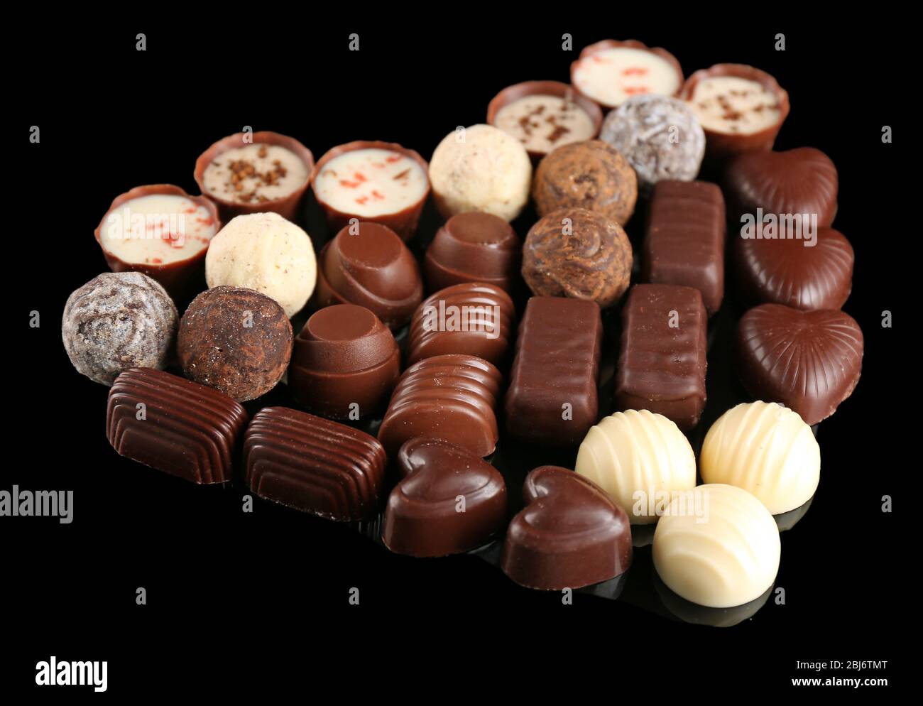 Assorted chocolate candies in form of heart on black background Stock Photo