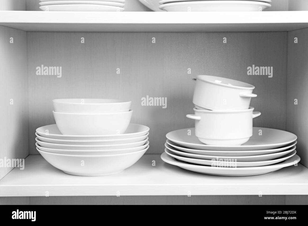 Dishes in cupboard in the kitchen Stock Photo Alamy