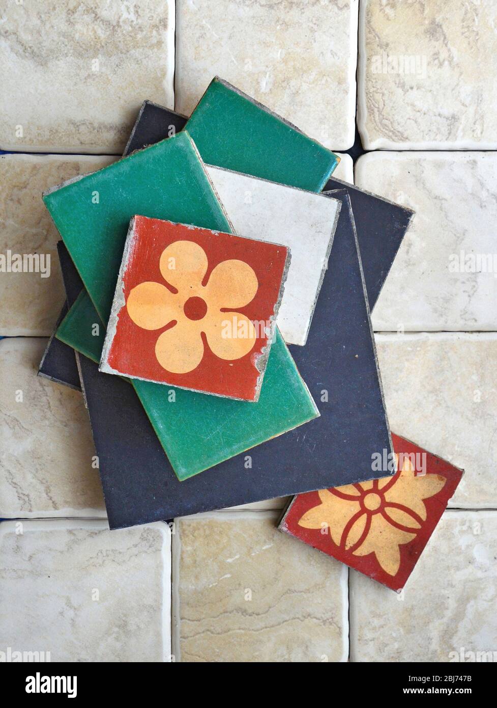 Variety of types and sizes of loose  Victorian floor ceramic tiles sitting on top of modern tiles. Stock Photo