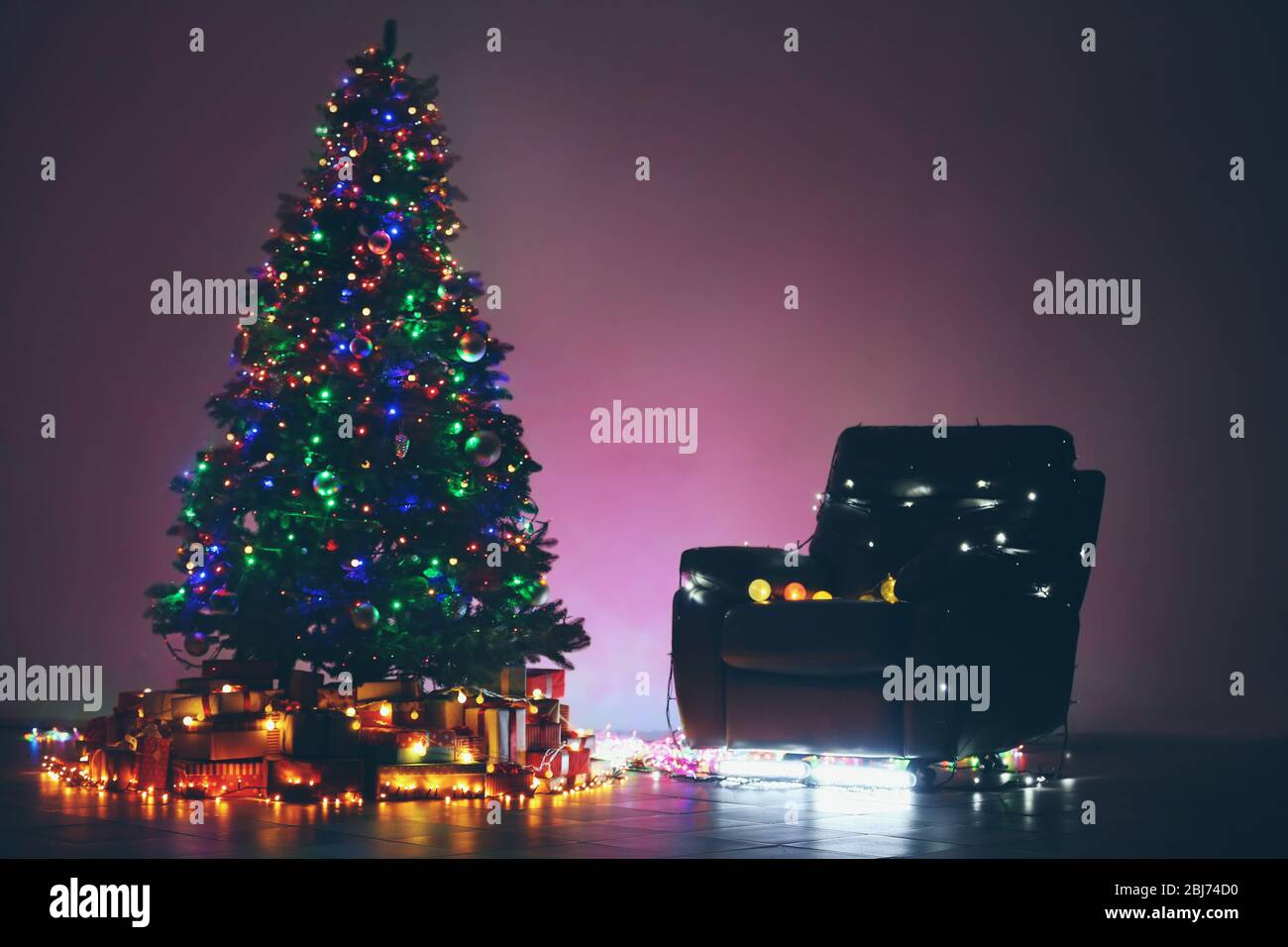 Christmas tree and armchair in a dark room Stock Photo - Alamy