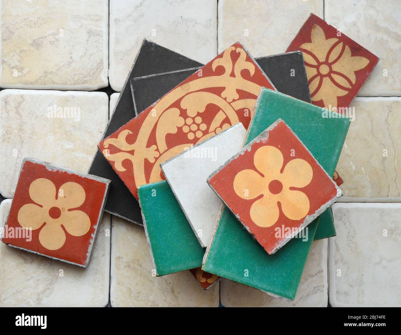 Variety of types and sizes of loose  Victorian floor ceramic tiles sitting on top of modern tiles. Stock Photo
