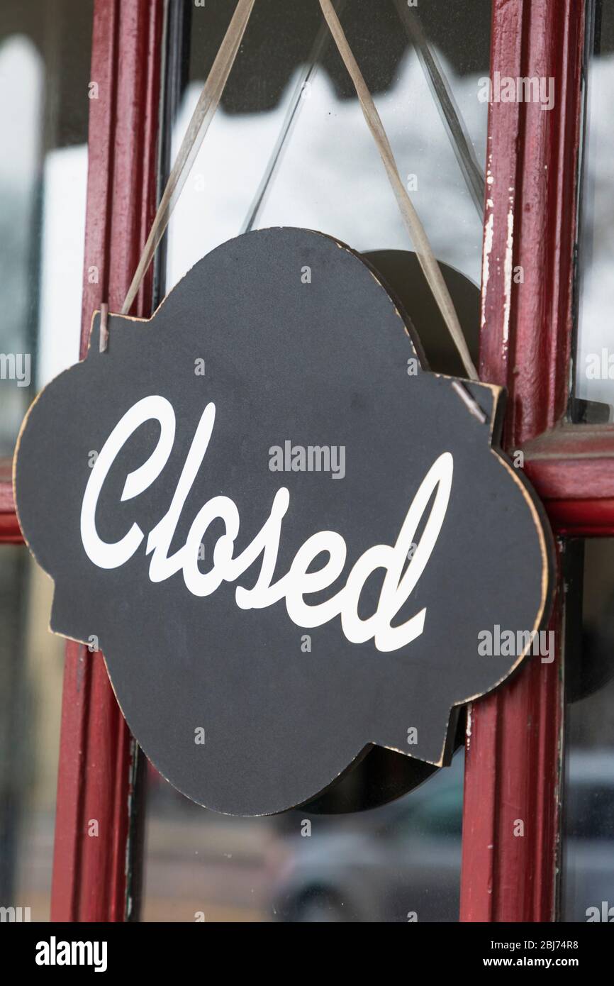 Closed sign on front door of local shop Stock Photo