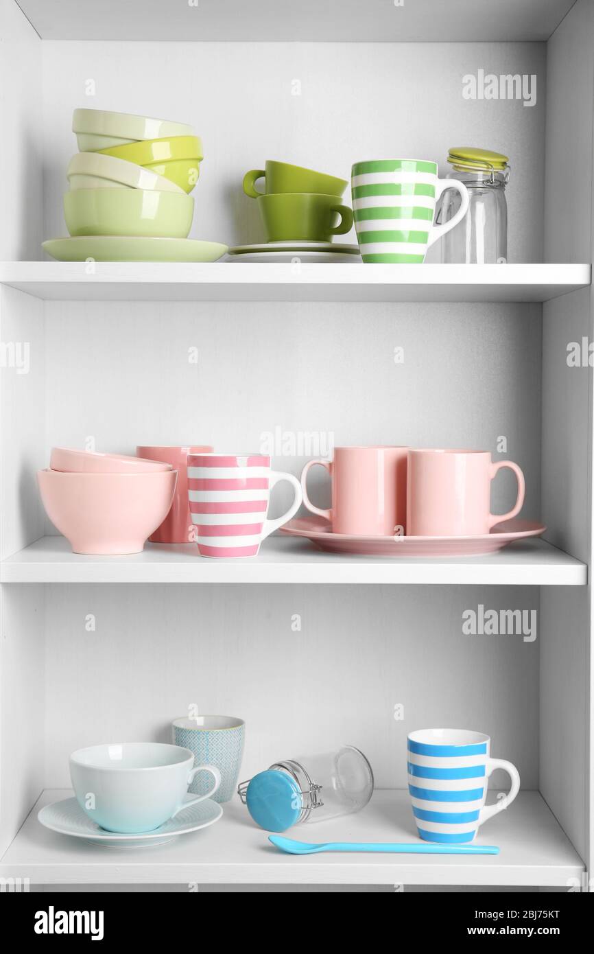 Tableware on shelves in the kitchen cupboard Stock Photo - Alamy