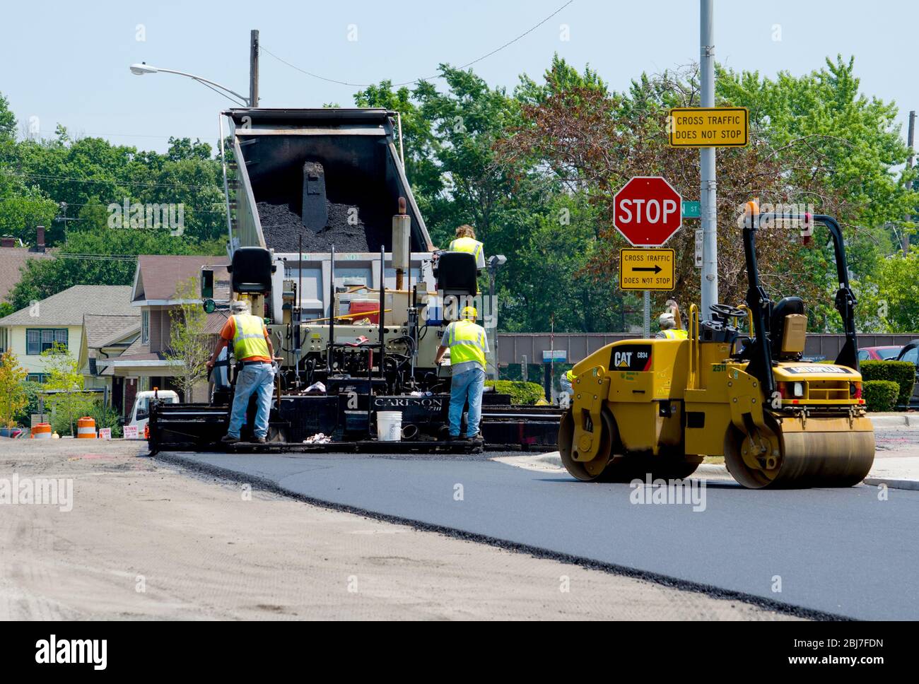 Construction crew work with hot asphalt to pave a road in a local Indiana  USA town Stock Photo - Alamy
