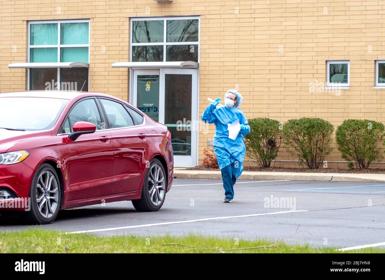 Benton Harbor Michigan USA April 233 2020; A nurse in personal protective gear comes to a car to test a unknown person possibly suffering from covid-1 Stock Photo