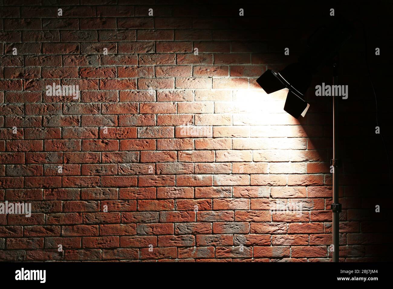 Studio light flash on brick wall background Stock Photo - Alamy