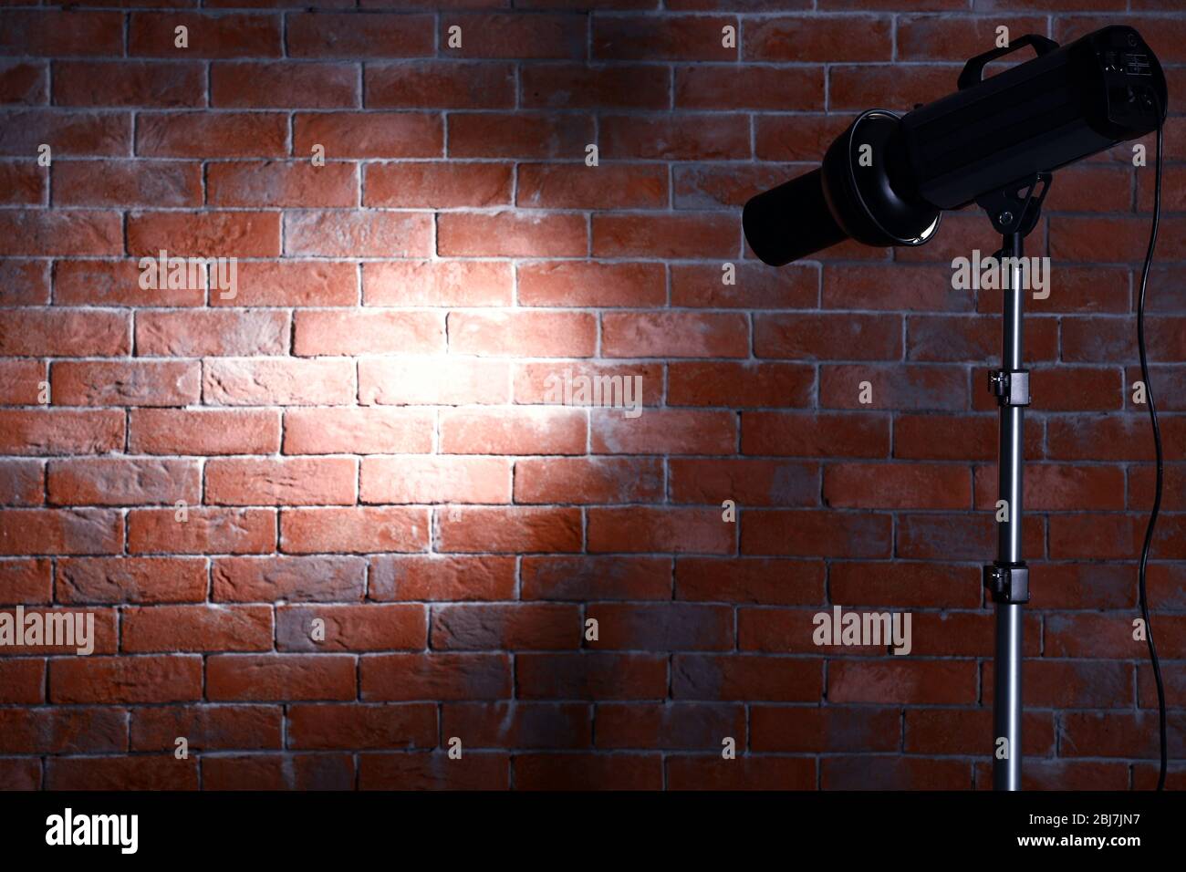 Studio light flash on brick wall background Stock Photo Alamy