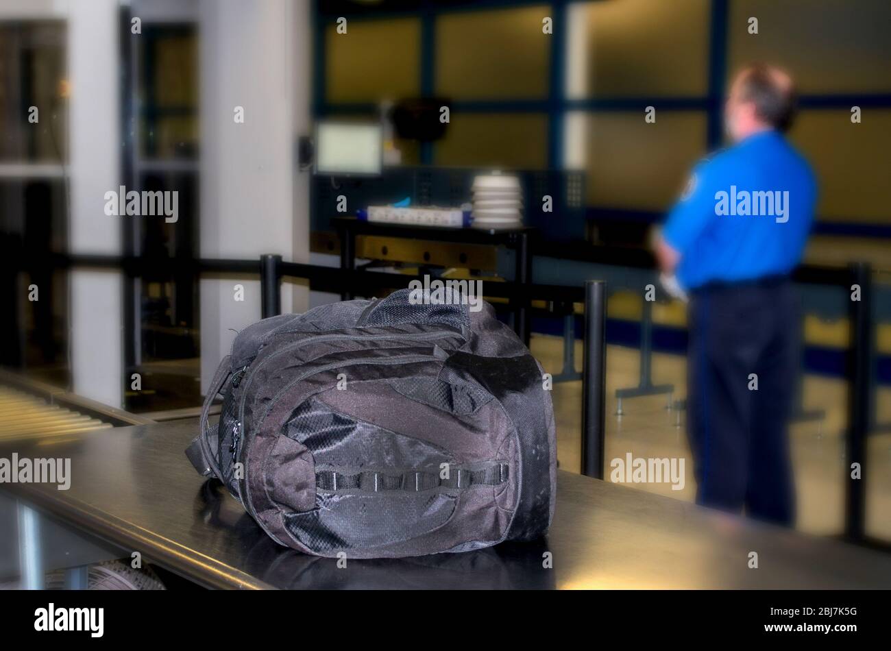 An unattended bag at an airport has so far gone unnoticed by a waiting airport worker Stock Photo