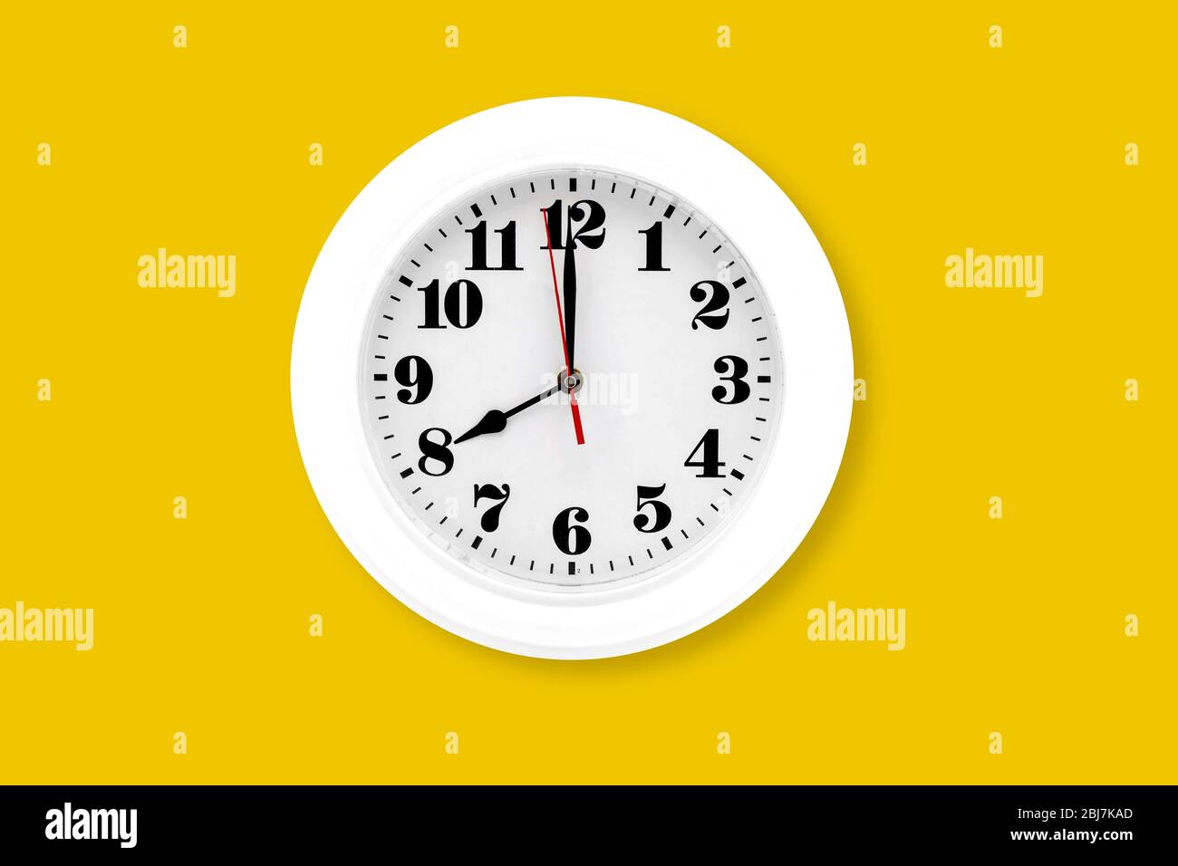 Modern wall clock white isolated on yellow background, time and period, office timepiece and mockup with hour and minute, hour hand, object classic. Stock Photo