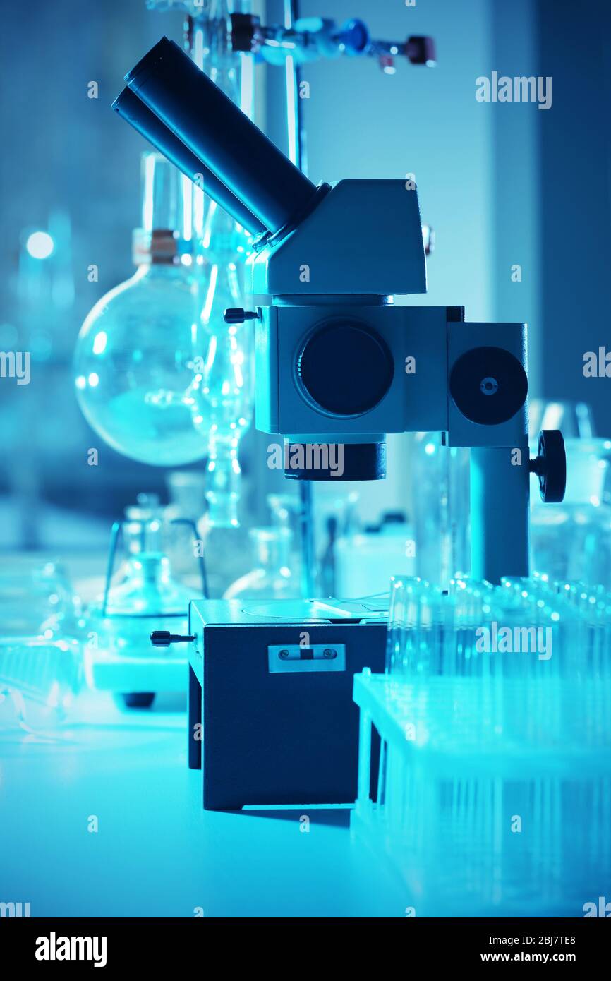 Microscope and different test tubes and flasks in laboratory Stock ...