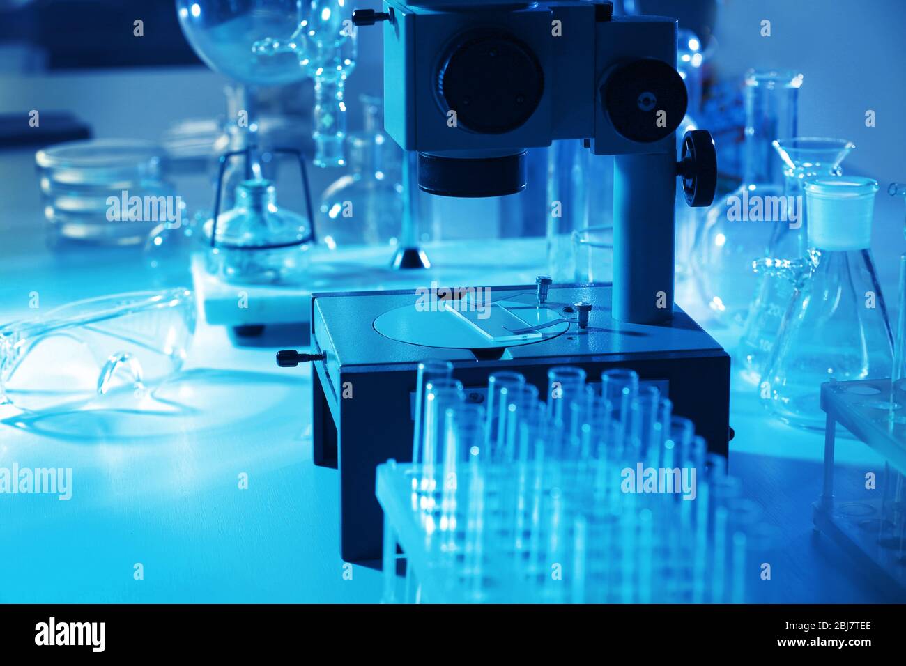 Microscope and different test tubes and flasks in laboratory Stock ...