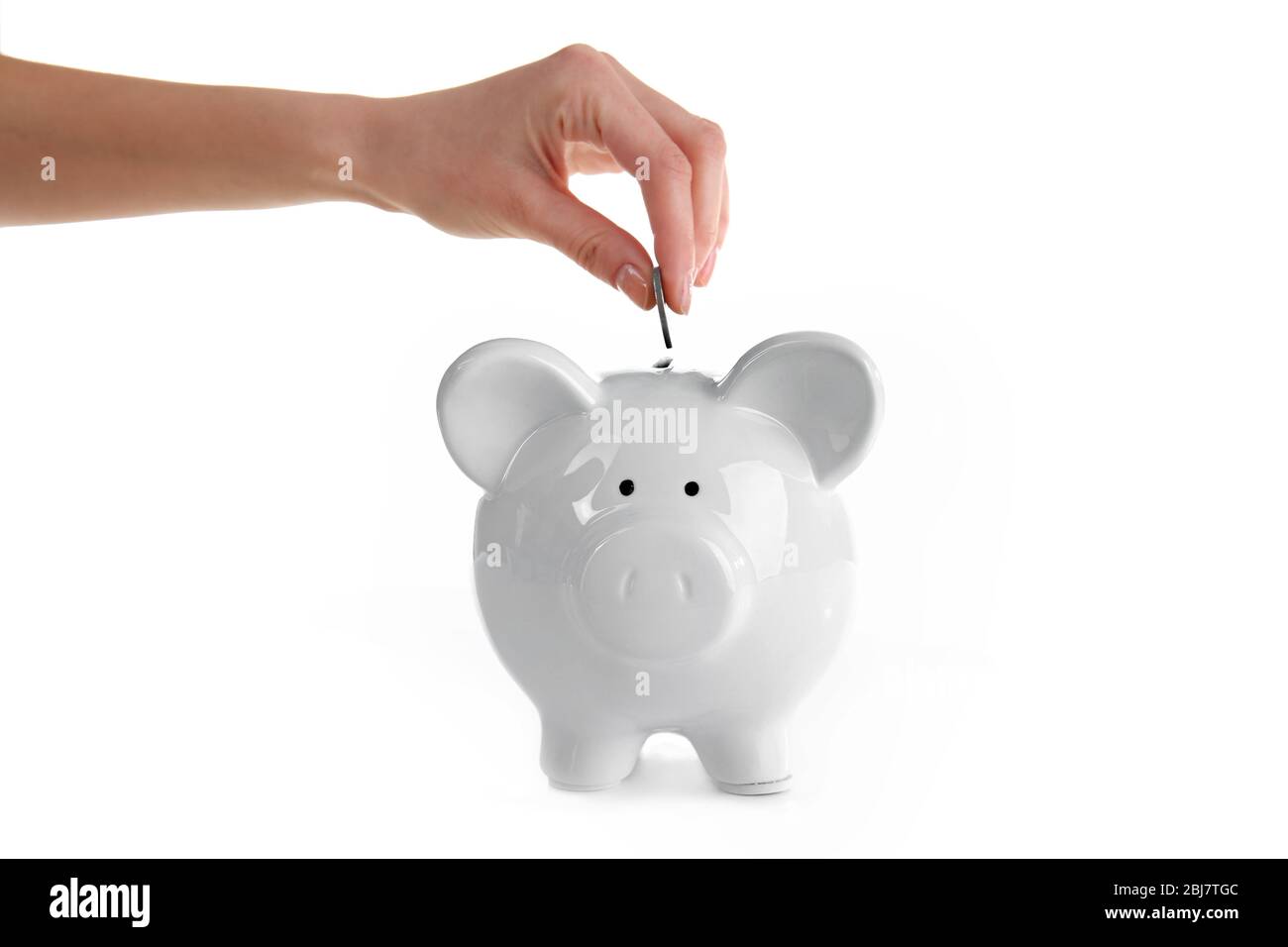 Hand putting coin into piggy bank, isolated on white Stock Photo - Alamy