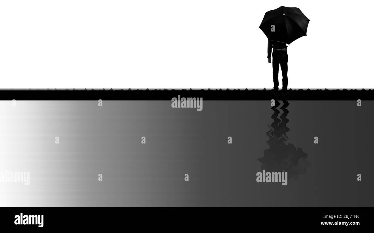 Creative minimalistic shot of man silhouette standing with a black umbrella along with its diminished reflection in water like below him, horizontal s Stock Photo