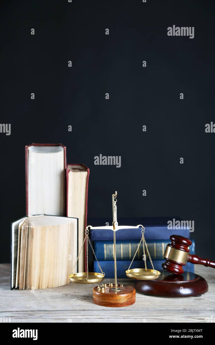 Wooden gavel with justice scales and books on black background Stock ...