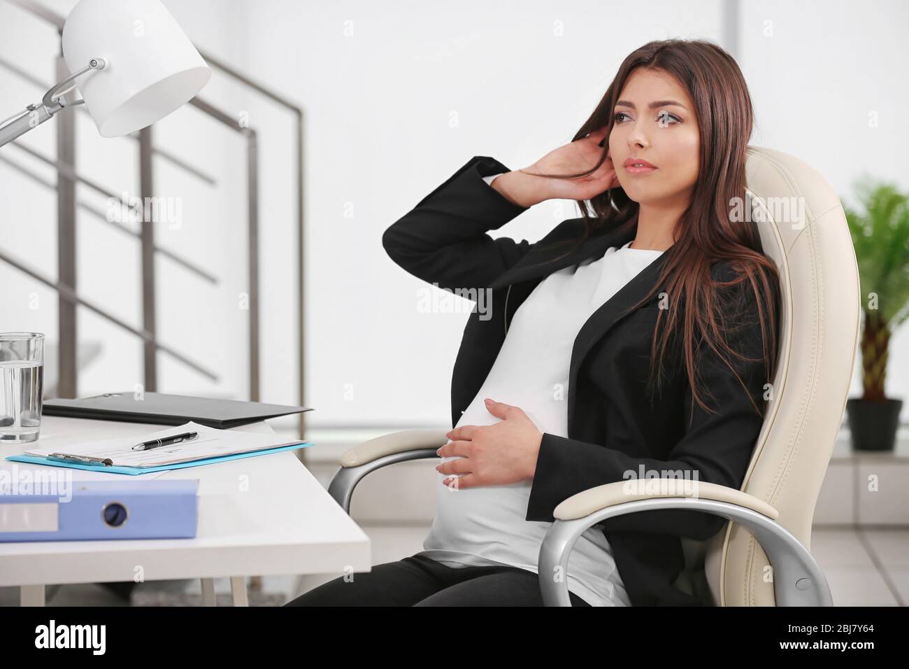 Premium AI Image  a pregnant woman sitting in an office chair