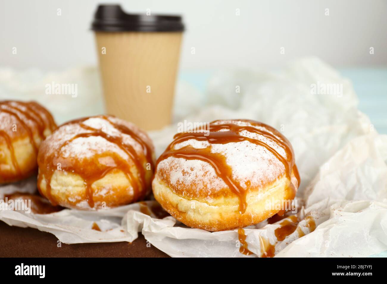 Delicious donuts with caramel on parchment closeup Stock Photo - Alamy