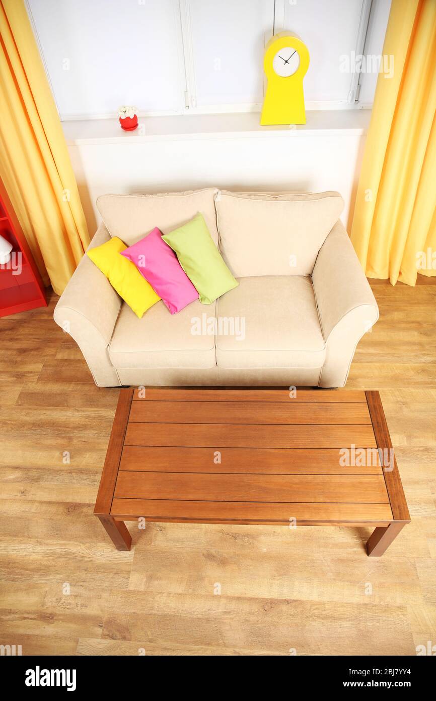 Modern living room interior with beige sofa and wooden coffee table