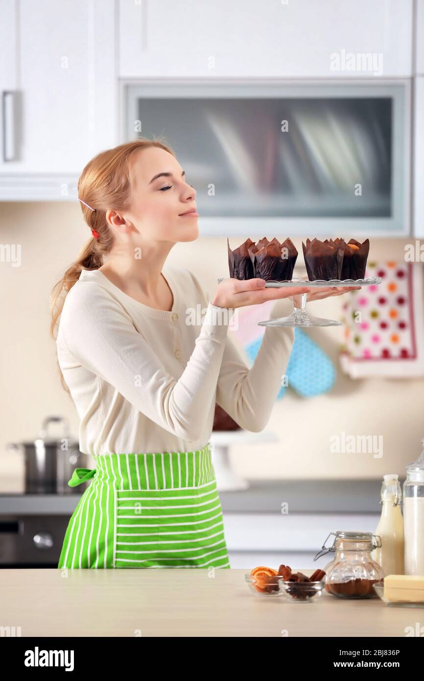 https://c8.alamy.com/comp/2BJ836P/young-woman-holding-a-plate-with-fresh-baked-cupcakes-2BJ836P.jpg