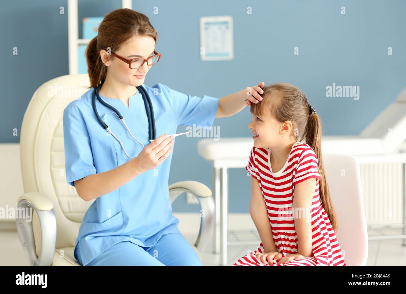 Doctor checking little girl's temperature Stock Photo Alamy
