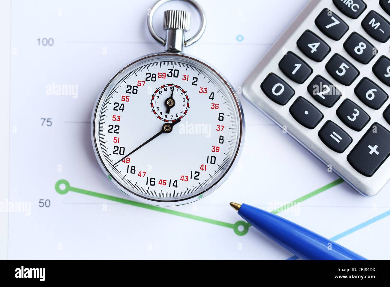 Stopwatch with calculator and pen on paper background Stock Photo - Alamy