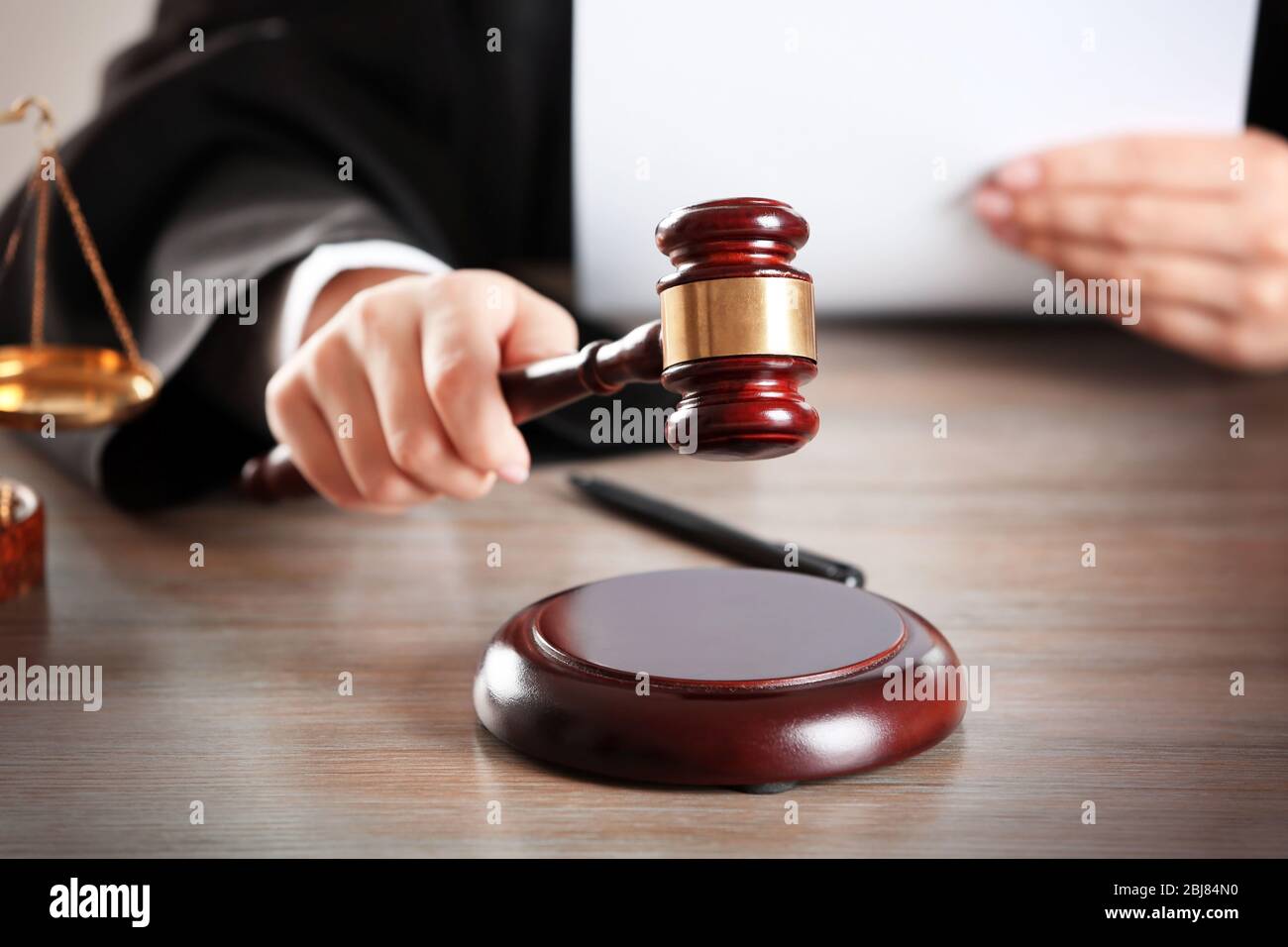 Judge hitting gavel with paper at wooden table closeup Stock Photo Alamy