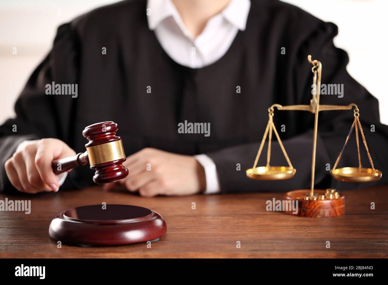 Judge hitting gavel at wooden table closeup Stock Photo