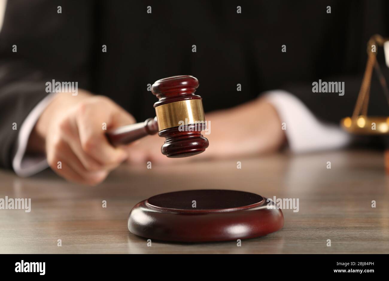 Judge hitting gavel at wooden table closeup Stock Photo Alamy