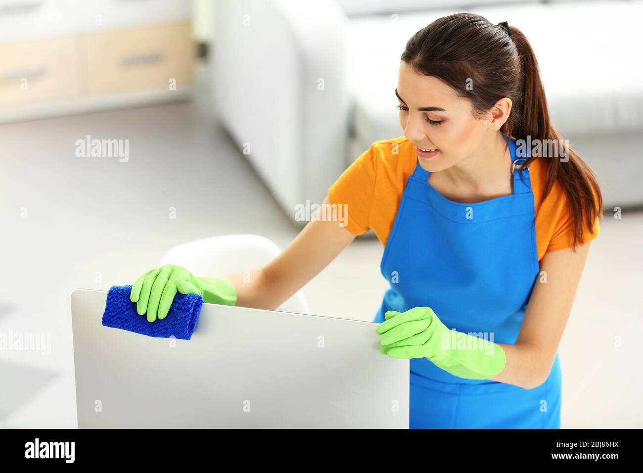 Young woman cleaning computer monitor in the office Stock Photo - Alamy